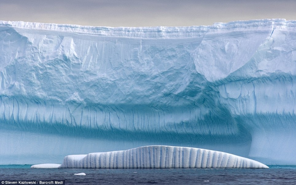 Giant ridges have been carved into the surface of this massive iceberg which dwarfs another smaller creation floating nearby  Read more: http://www.dailymail.co.uk/news/worldnews/article-1258041/Incredible-pictures-giant-ice-sculptures-carved-sea-water-polar-winds.html#ixzz0kwd4Wd47