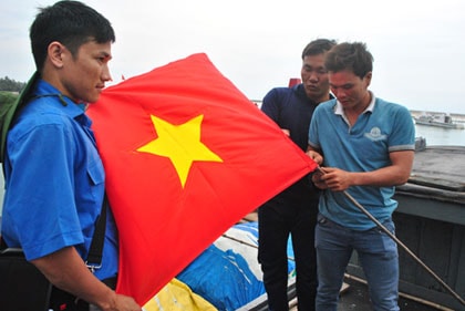 Các bạn sinh viên trao cờ Tổ Quốc cho ngư dân huyện đảo Lý Sơn.
