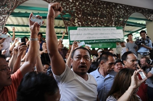 Người dân Thái Lan giơ cao chứng minh thư nhân dân Frustrated Thai voters hold their national identification cards and shout at police blocking the entrance to a polling station as voting was cancelled after anti-government protesters prevented the delivery of election material in downtown Bangkok on February 2, 2014 