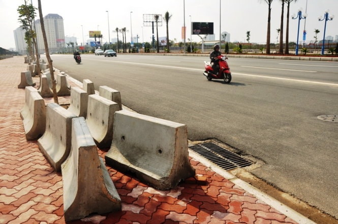 Những khối bê tông dùng để phân cách đường vẫn chưa được di chuyển khỏi khỏi vĩa hè - Ảnh: QUANG THẾ