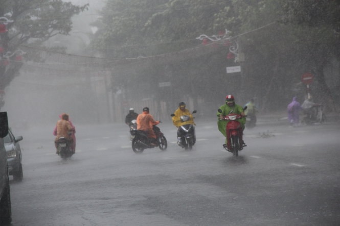 Nhiều người di chuyển rất khó khăn bởi mưa rất to, gió lớn trên đường Bạch Đằng - Ảnh: Phan Thành