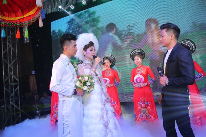 Chú rể Trần Phi Hùng thay áo dài truyền thống, sóng đôi bên cô dâu xinh đẹp trên sân khấu. 