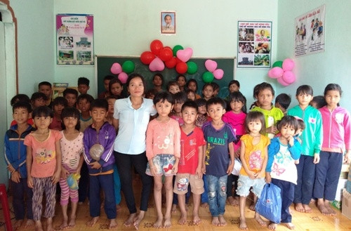 Cô giáo BLao (áo trắng) đứng trên đôi chân co quắp cùng các học trò. Ảnh: Việt Hiến.