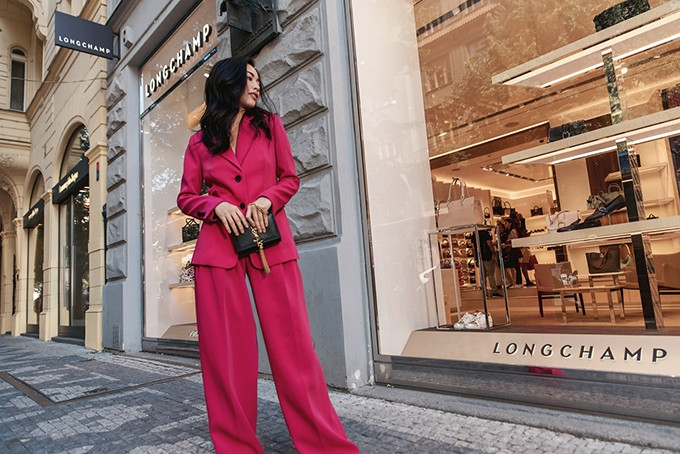 Clutch kiểu dáng sang trọng của Yves Saint Laurent tạo điểm nhấn cho bộ suit tông hồng nổi bật.