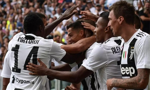 Đồng đội chia vui với Ronaldo sau khi ghi bàn thắng đầu tiên cho Juventus ở trận thắng Sassuolo. Ảnh: AFP.