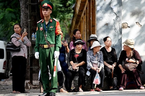 Người dân ngồi chờ bên ngoài nhà tang lễ để vào viếng Chủ tịch nước. Ảnh: AFP