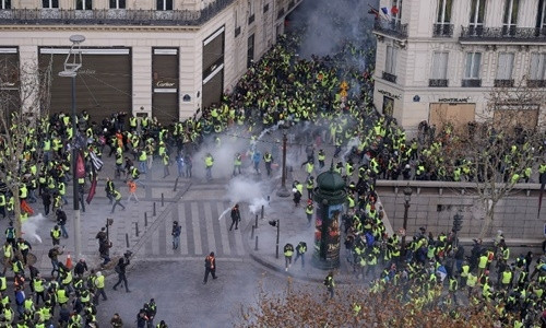 Người biểu tình áo vàng đụng độ với cảnh sát ở Paris ngày 8/12. Ảnh: AFP.