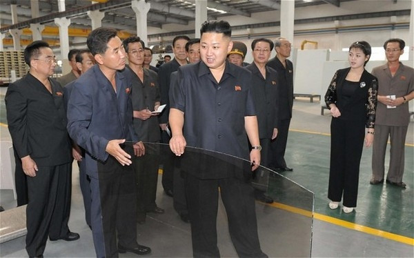 Nhà lãnh đạo Kim Jong-un trong trang phục hiện đại hơn với áo sơ mi đen ngắn tay cùng quần kaki suông trong chuyến thăm một nhà máy ngói ở Bình Nhưỡng