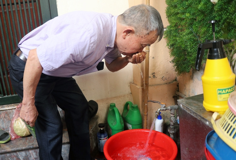 Ông Đinh Tiến Dũng - Bí thư chi bộ cụm cơ khí 1A (Thanh Xuân) cho hay nước có mùi nên gia đình phải mua nước đóng bình về sử dụng. Ảnh: Võ Hải.