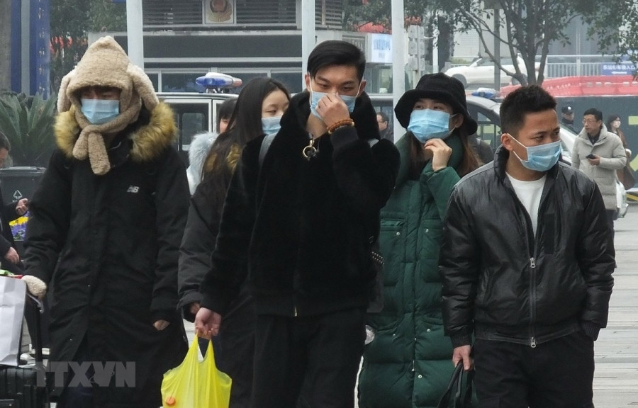 Hành khách đeo khẩu trang đề phòng lây nhiễm virus corona. (Ảnh: AFP/TTXVN)
