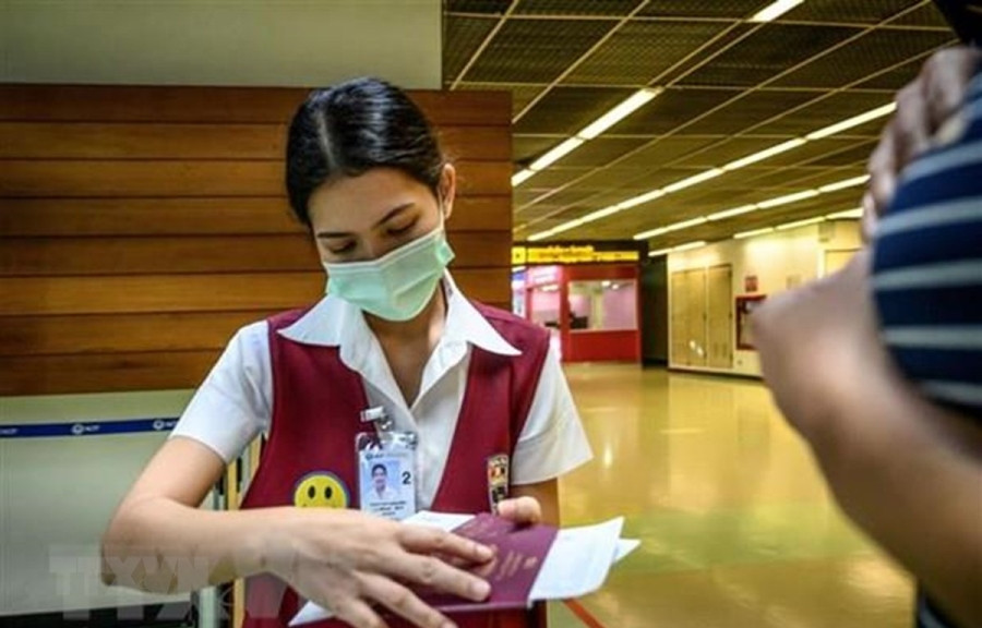 Nhân viên kiểm tra hộ chiếu của một hành khách tại sân bay Don Mueang ở Bangkok, Thái Lan, ngày 21/1/2020. (Ảnh: AFP/TTXVN)