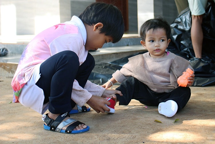 Bé Rahlan H Ưn dân tộc Gia Rai. 6 tuổi (bên trái), được ông Nhật nhận nuôi lúc 1 tuổi, do cha mẹ mất sớm và bé Đinh Thị Thùy Trâm (bên phải), 1 tuổi. Bé Trâm được nhận về từ lúc 4 tháng. Mẹ bé mất sớm, bà ngoại già không nuôi nổi nên đem đến gửi ông Nhật. Ảnh: Phan Diệp.