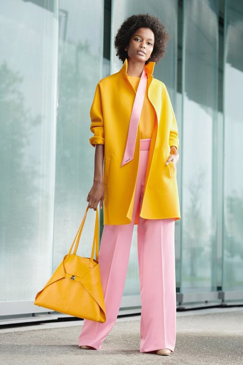 Áo khoác vàng chanh rực rỡ, quần ống đứng tông hồng pastel, giày cao gót tông nude vừa thanh lịch vừa kích thích thị giác cao. 