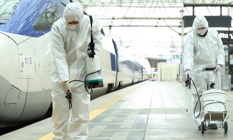 Nhân viên đường sắt Hàn Quốc phun thuốc khử trùng tại một ga tàu ở Seoul hôm 25/2. Ảnh: AFP.