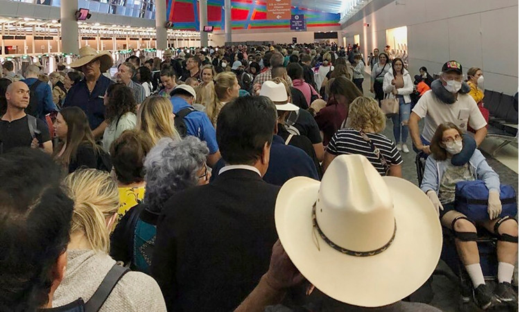 Hành khách chen chúc chờ đợi làm thủ tục ở sân bay quốc tế Fort Worth ở Dallas hôm 14/3. Ảnh: AP.