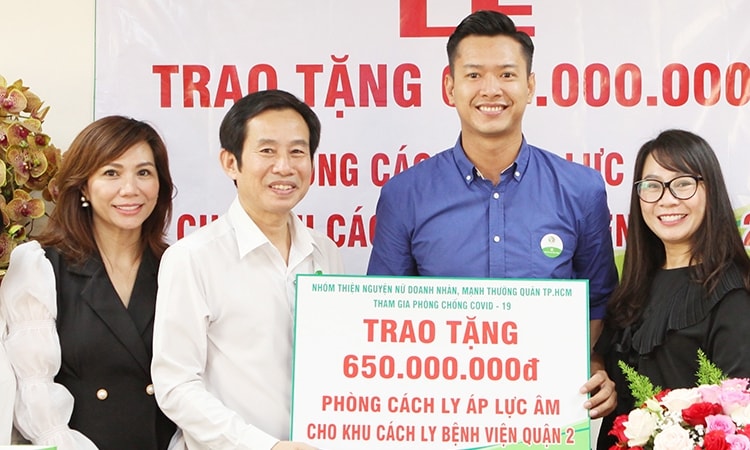 Hồ Đức Vĩnh (thứ hai từ phải sang) trao tiền mặt tài trợ phòng cách ly áp lực âm cho đại diện bệnh viện quận 2 TP HCM - bác sĩ Trần Văn Khanh (thứ hai từ trái sang). Ảnh: Nhân vật cung cấp. 