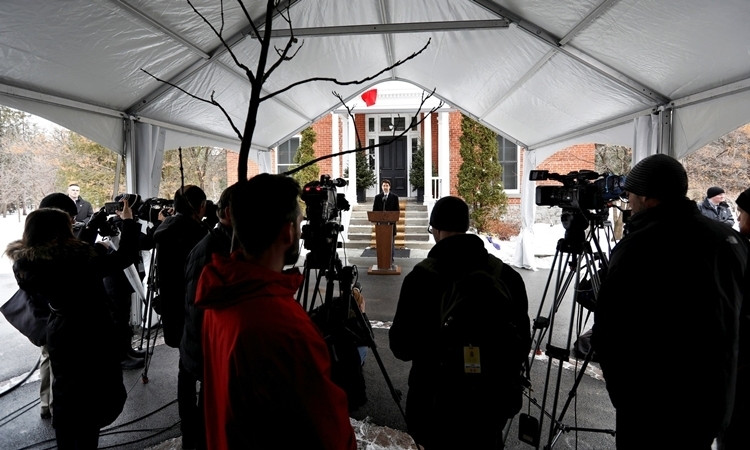 Thủ tướng Justin Trudeau tuần trước họp báo trong quãng thời gian cách ly tại Rideau Cottage, các phóng viên đứng ở khoảng cách an toàn. Anhr: Reuters.