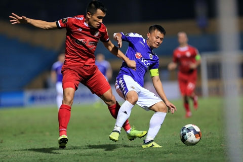 Thành Lương (phải) vất vả giữ bóng trước sự đeo bám rát của cầu thủ TP.HCMẢnh: Minh Tuấn