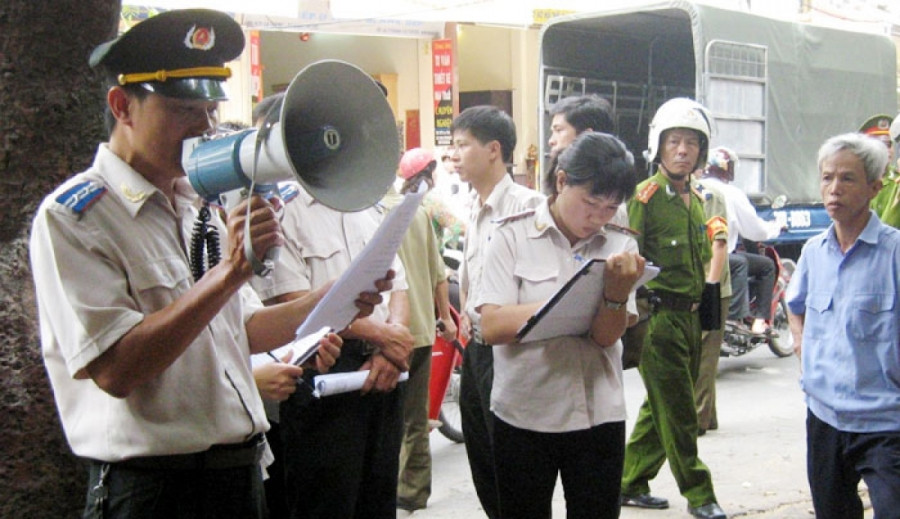 Cán bộ thực hiện thi hành án dân sự tại một cơ sở ở Hà Nội. Ảnh minh họa.