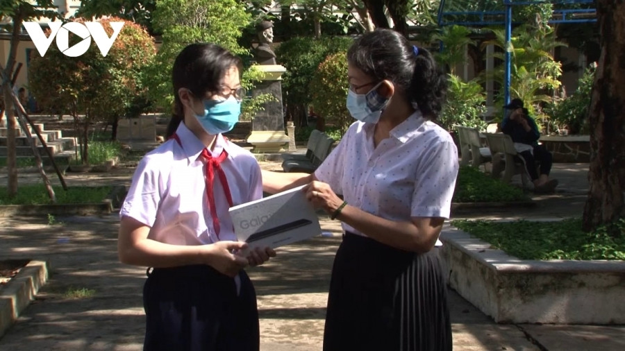 Cô Nguyễn Thị An (bên phải), Hiệu trưởng Trường THCS Huỳnh Thúc Kháng, quận Thanh Khê, Đà Nẵng trao tận tay học sinh hoàn cảnh khó khăn chiếc máy tính bảng.
