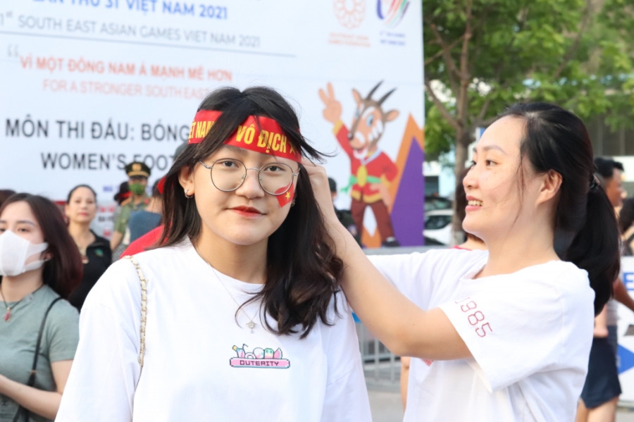 CĐV dán lá cờ đỏ trên má để cỗ vũ cho tuyển Việt Nam.