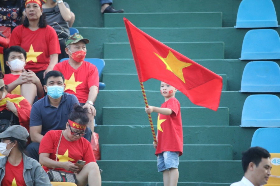 Cổ động viên nhí cầm cờ cổ vũ cho Việt Nam.