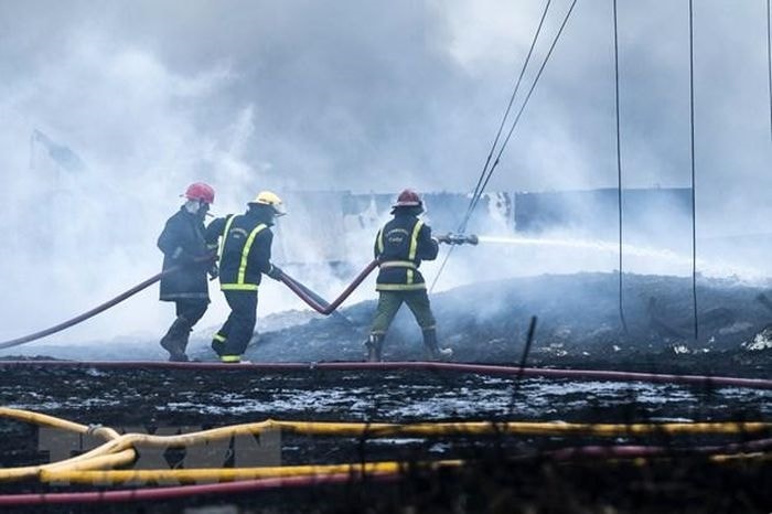 Lực lượng cứu hỏa dập đám cháy. (Ảnh: AFP/TTXVN)