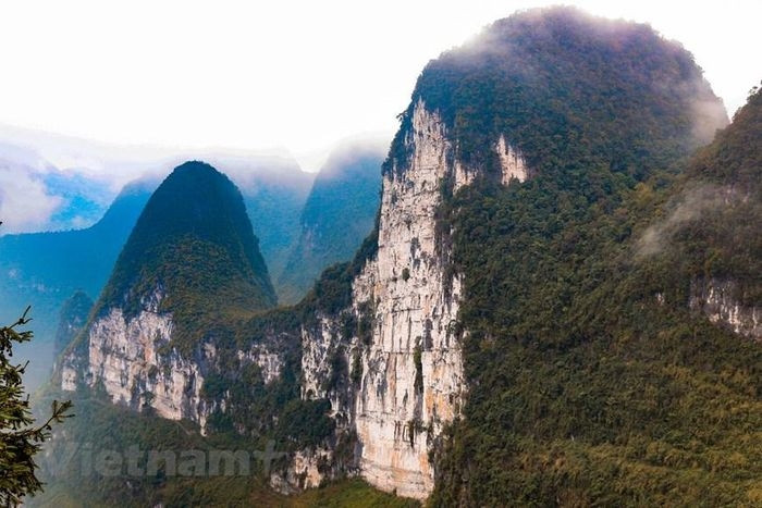  Tại chân Đèo Mã Pì Lèng, bạn có thể phóng tầm mắt đến Vách đá trắng Hà Giang. Khi chinh phục vách đá này bạn chắc chắn sẽ phải trầm trồ trước vẻ đẹp thiên nhiên hùng vĩ, mây trời trong xanh, dòng sông Nho Quế uốn lượn xẻ đôi cả núi đồi. (Ảnh: Hoài Nam/Vietnam+) 