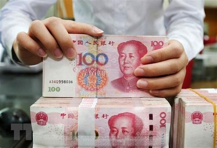 Nhân viên ngân hàng kiểm tiền mệnh giá 100 nhân dân tệ tại tỉnh Giang Tô, Trung Quốc. (Ảnh: AFP/TTXVN)