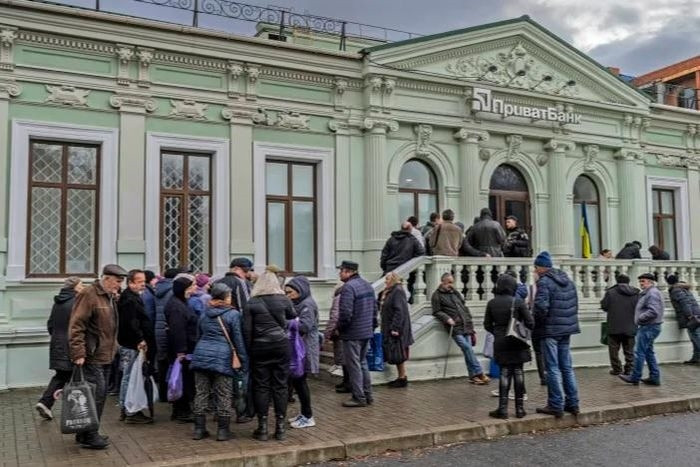 Người dân xếp hàng tại một chi nhánh ngân hàng ở Kherson, miền nam Ukraine, ngày 21/11. Ảnh: AP