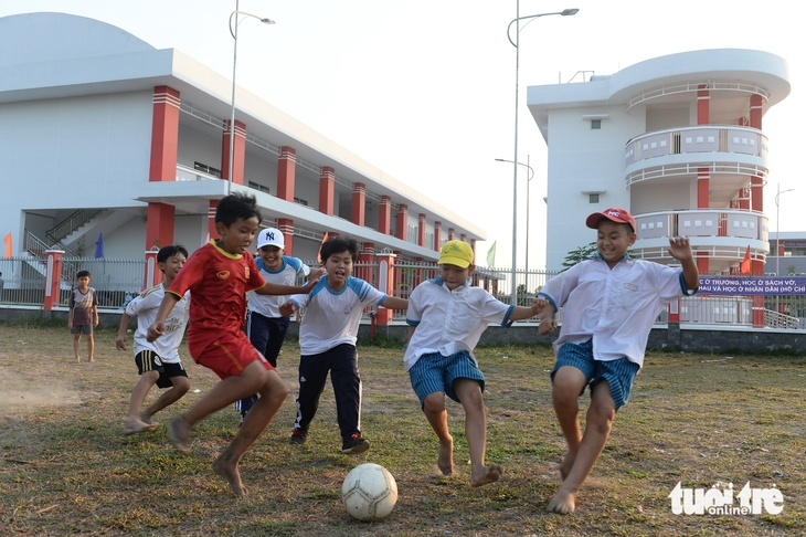 Không nên cho trẻ tham gia các trò chơi vận động mạnh như đá bóng dưới trời nắng nóng. Trong ảnh: học sinh đá bóng bên cạnh Trường tiểu học Bình Lợi (huyện Bình Chánh, TP.HCM) - Ảnh: TỰ TRUNG