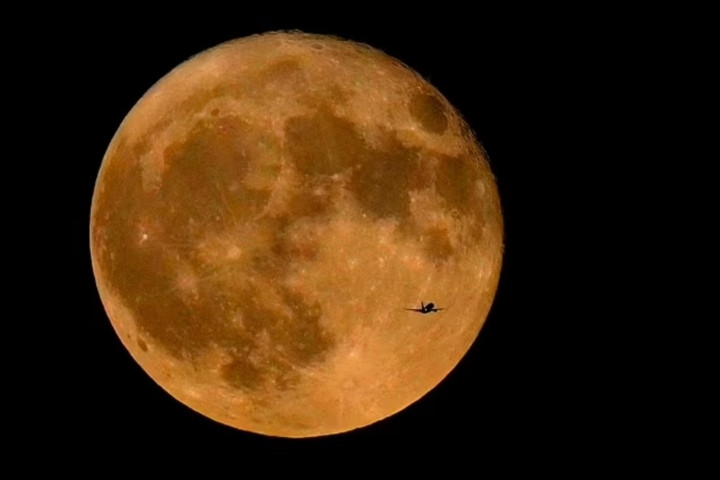 Máy bay thương mại bay qua Hồ Michigan trước siêu trăng tháng 7/2023, siêu trăng đầu tiên trong bốn siêu trăng của năm 2023. (Ảnh: AP)