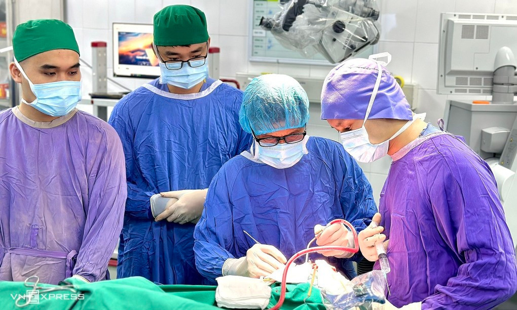 Bác sĩ Hệ (ngồi chính giữa) cùng đồng nghiệp đang thực hiện ca phẫu thuật cho bệnh nhân mắc u não, ngày 21/7. Ảnh: Minh An