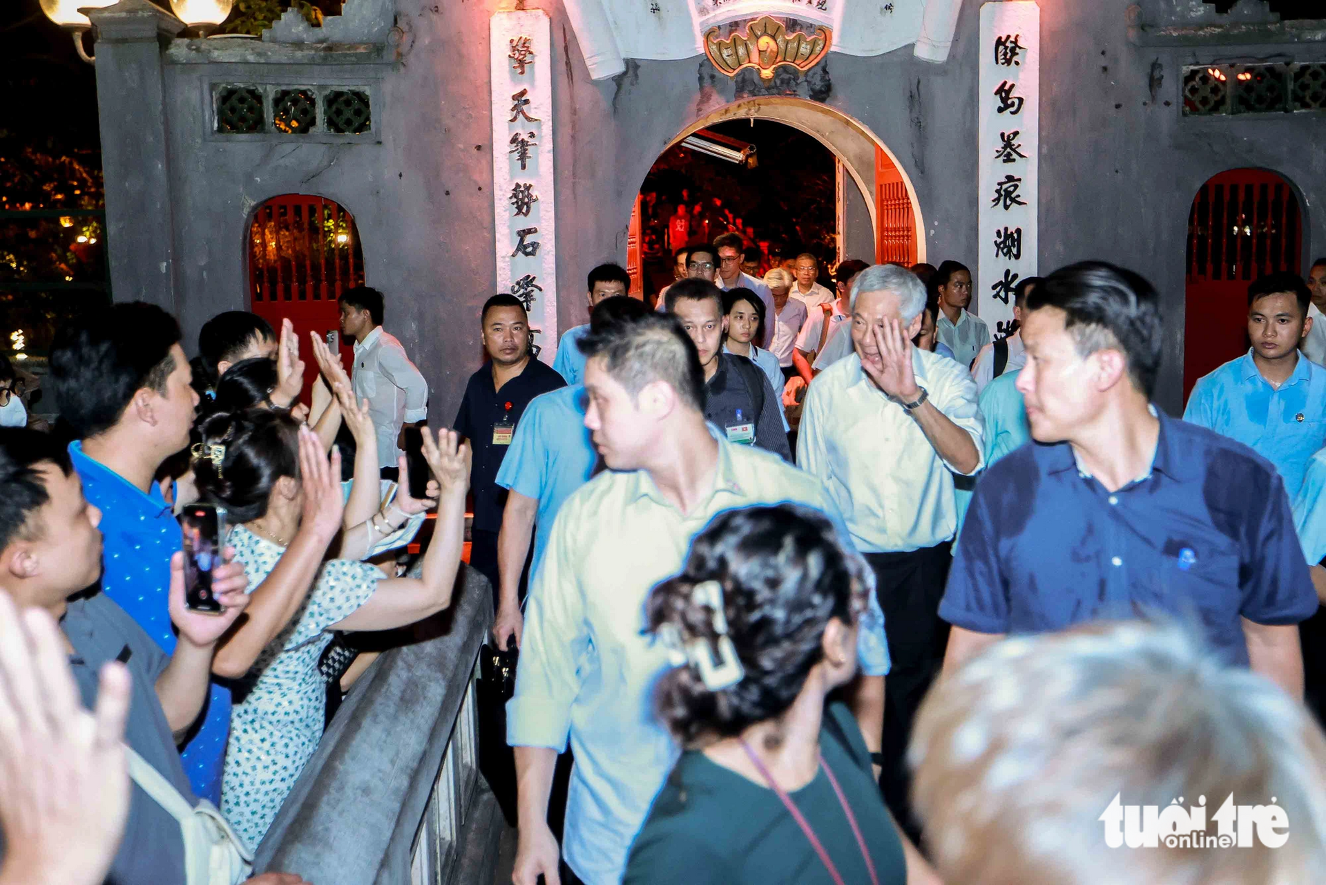 Thủ tướng Lý Hiển Long mỉm cười vẫy tay chào những người dân Hà Nội - Ảnh: NGUYỄN KHÁNH