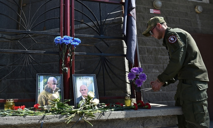 Thành viên Wagner đặt hoa tưởng niệm trước ảnh Yevgeny Prigozhin và Dmitry Utkin bên ngoài văn phòng tại Novosibirsk, Nga, hôm 24/8. Ảnh: Reuters