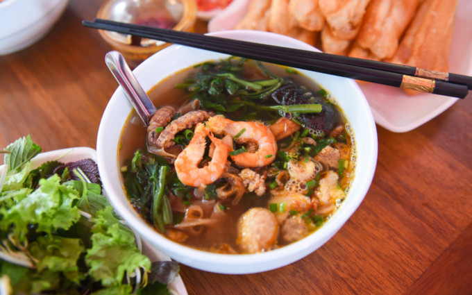 Crab noodle soup is a specialty in Hai Phong, often served with fried dough and herbs. Photo by VnExpress/Duy Tung
