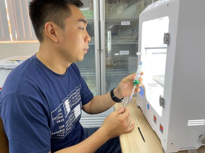 Thạc sĩ Vũ Thanh Bình kiểm tra thiết bị máy in 3D sinh học phục vụ việc sử dụng gel làm mực in, tạo hình khung xương nhân tạo. Ảnh: Hà An