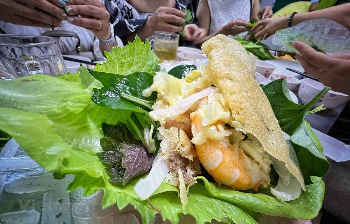 Du khách thưởng thức bánh xèo, món ngon Sài thành. (Ảnh: Mai Mai/Vietnam+)