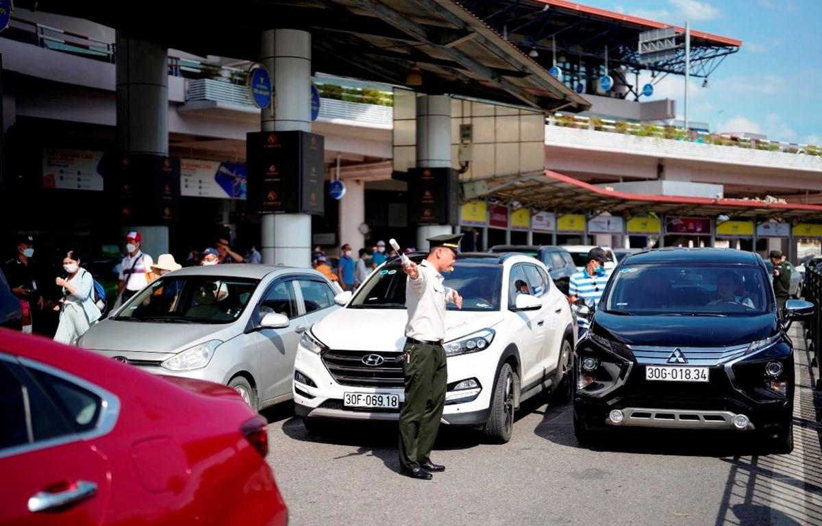 Nhân viên an ninh hàng không phân làn phương tiện đi vào làn đỗ tại Nhà ga T1 Sân bay Quốc tế Nội Bài. (Ảnh: CTV/Vietnam+