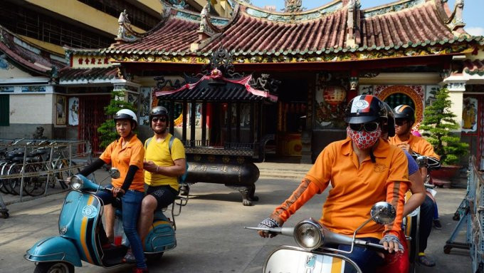 Tài xế chở du khách nước ngoài tham quan chùa cổ ở TP HCM bằng xe Vespa. Ảnh: Mark Eveleigh