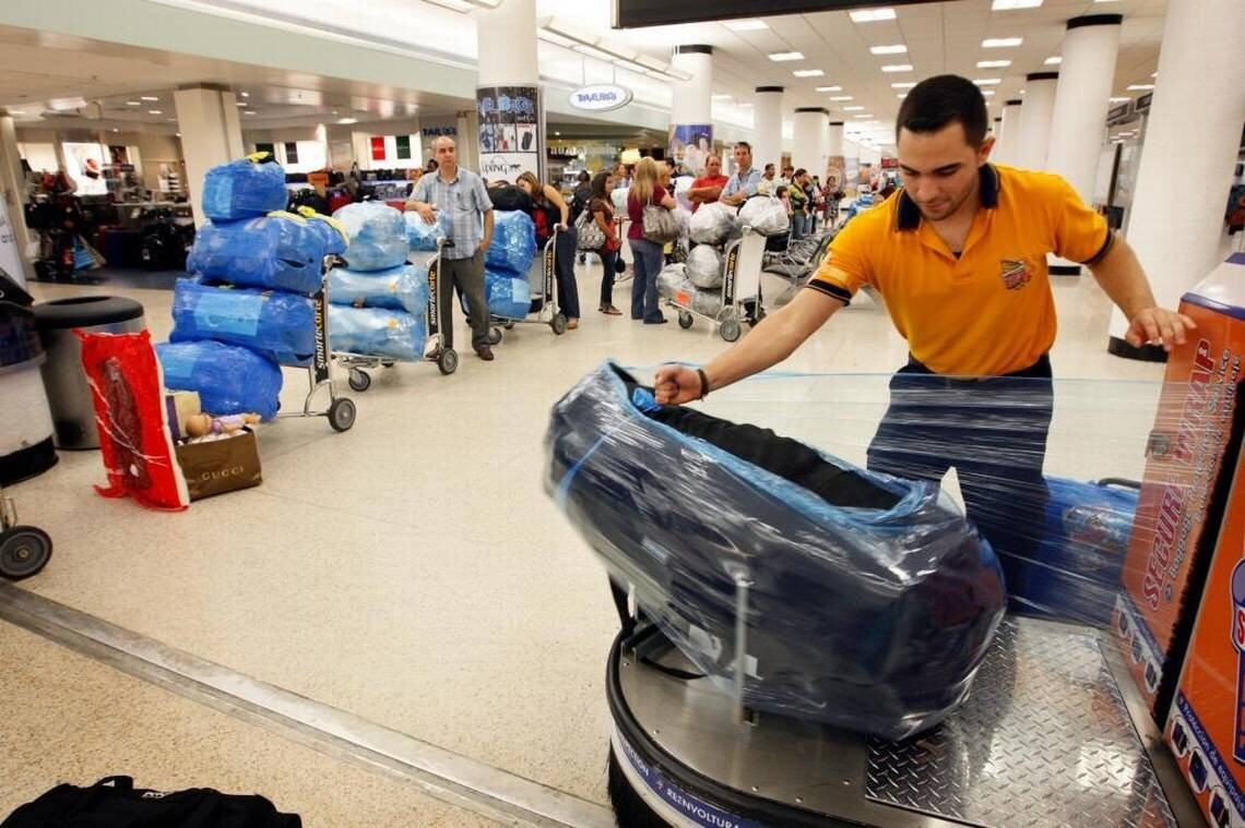Có nên bọc hành lý ký gửi bằng nylon? Cách này vừa bất tiện vừa không thân thiện với môi trường. (Ảnh: Miami Herald)