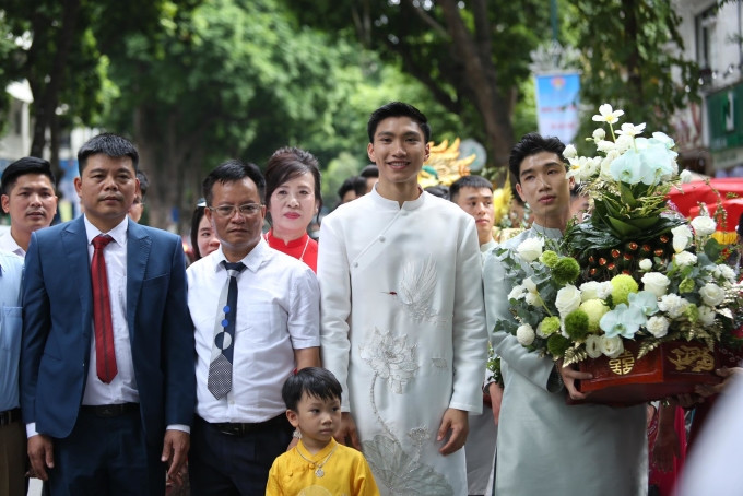 Văn Hậu (áo dài trắng) và đoàn nhà trai chụp ảnh trước khi vào nhà gái làm lễ.