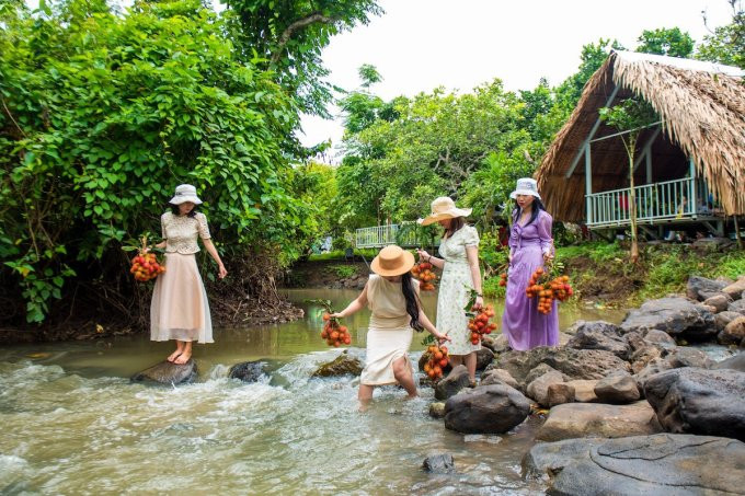 Du khách vui chơi bên một con suối ở nhà vườn TP Long Khánh. Ảnh: Lò Văn Hợp