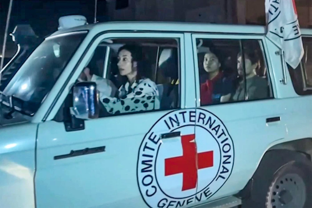 Xe của Ủy ban Chữ thập Đỏ Quốc tế (ICRC) tiếp nhận các con tin được Phong trào Hồi giáo Hamas trả tự do sau thỏa thuận ngừng bắn tại Gaza. (Ảnh: AFP/TTXVN) 
