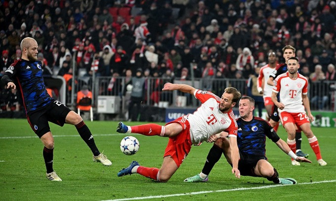 Kane (trắng đỏ) ngả người dứt điểm trong tình huống bị hậu vệ Copenhagen theo kèm trên sân Allianz Arena hôm 29/11. Ảnh: Reuters