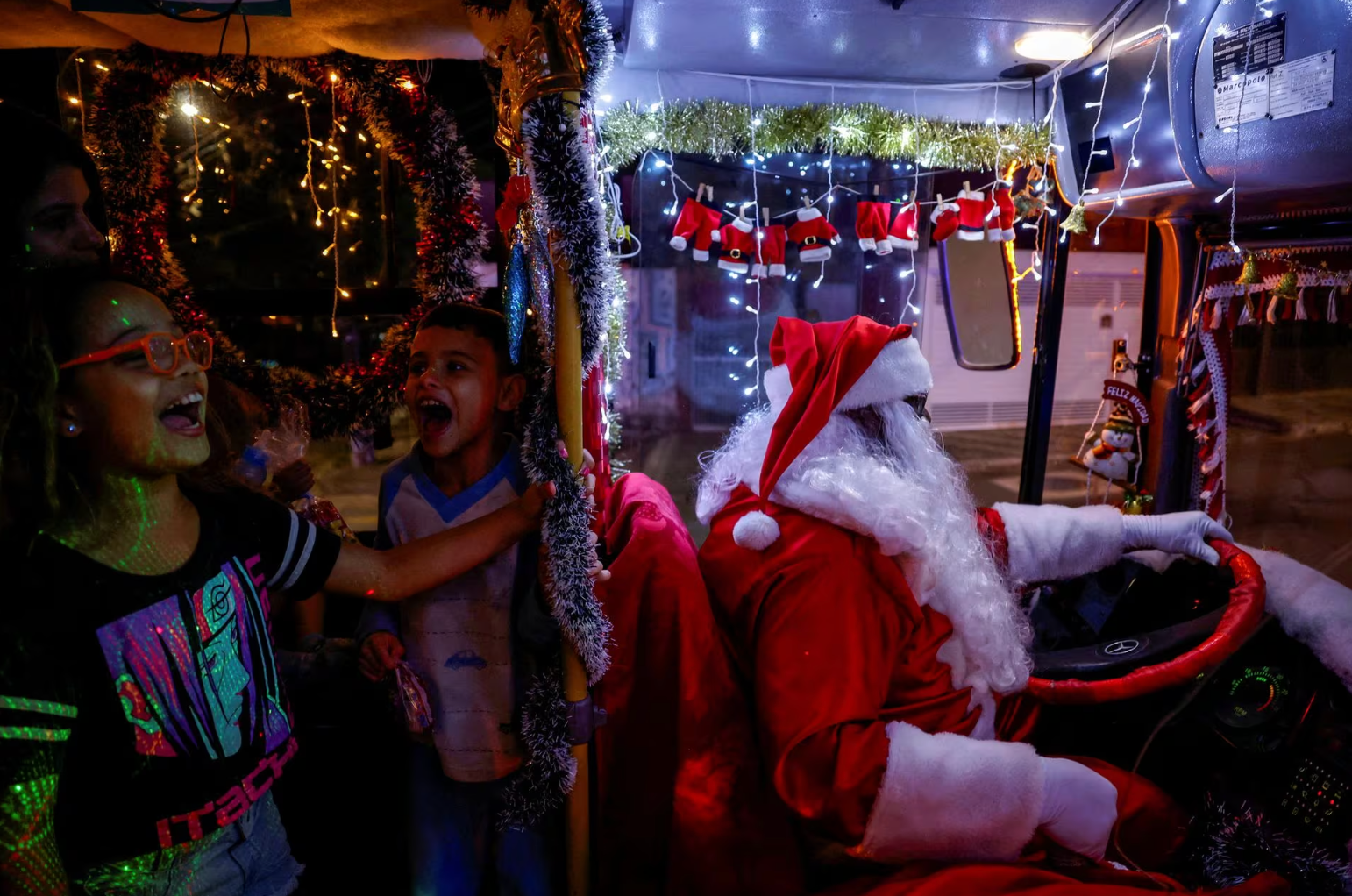 Ông Edilson Santos hóa trang thành ông già Noel và lái chiếc xe buýt được trang trí theo chủ đề Giáng sinh tại thành phố Jardim Alzira Franco, ở bang Santo Andre (Brazil) vào ngày 19-12 - Ảnh: REUTERS