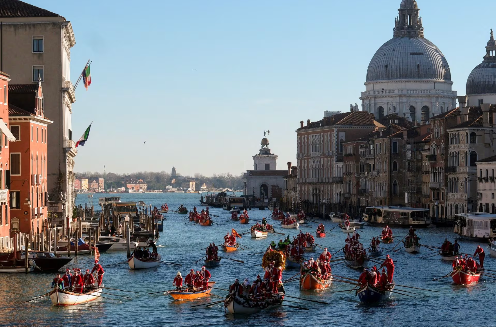 Người dân và du khách hóa trang thành ông già Noel và chèo thuyền tại sông Venice, Ý vào ngày 17-12 - Ảnh: REUTERS