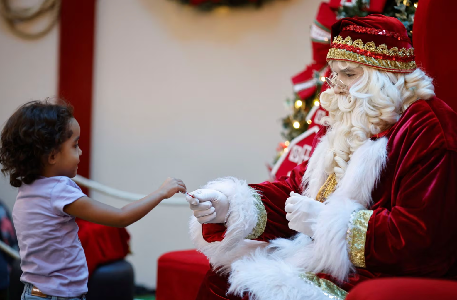 Một đứa trẻ thích thú khi nhận được quà từ ông già Noel tại trung tâm mua sắm ở thủ đô Brasilia, Brazil ngày 29-11 - Ảnh: REUTERS