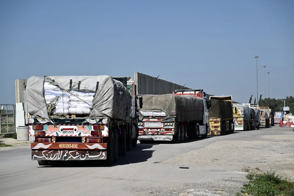 Đoàn xe chở hàng viện trợ di chuyển từ Ai Cập qua cửa khẩu Kerem Shalom vào phía Nam Dải Gaza, ngày 22/12. (Ảnh: AFP/TTXVN)