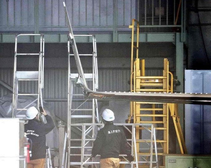 Kỹ thuật viên Cảnh sát biển Nhật Bản khám nghiệm máy bay sau vụ va chạm ở sân bay Haneda hôm 4/1. Ảnh: Yomiuri Shimbun